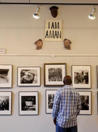 A man looking at photographs displayed inside Withers Collection Museum & Gallery.