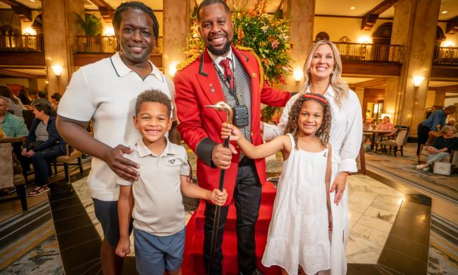 family of four poses with Peabody Duck Master.