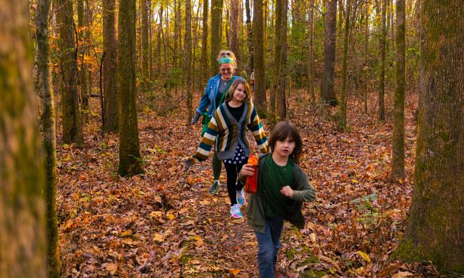family of three hikes through stanky creek