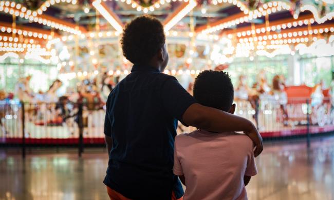 Two children standing in front of the Grand Carousel at Children's Museum of Memphis.