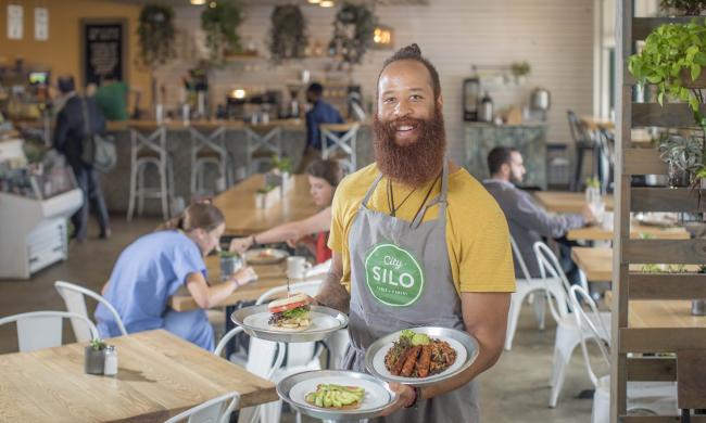 City Silo employee poses with various dishes.