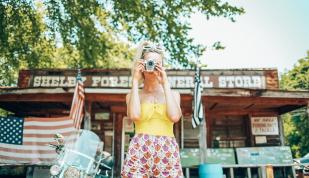 Girl snapping a photo in front of Shelby Forest General Store in Millington near Memphis | Oui We Girl