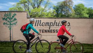 two woman bike in front of memphis Tennessee mural